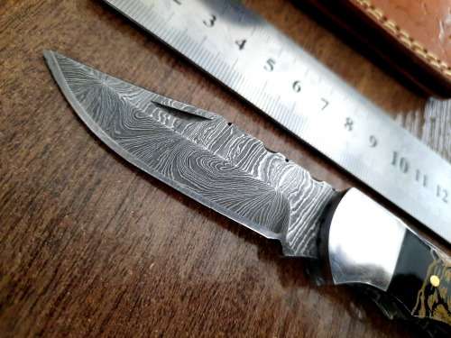 Handmade Damascus steel folding knife with Bull Horn Handle. Art engraved.
