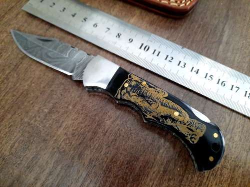 Handmade Damascus steel folding knife with Bull Horn Handle. Art engraved.