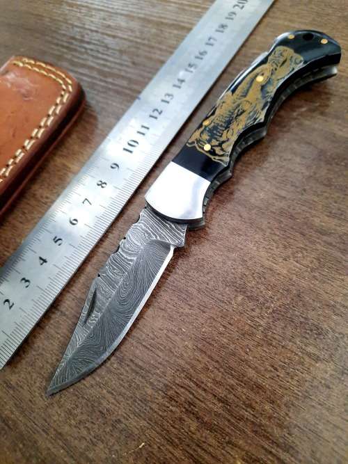 Handmade Damascus steel folding knife with Bull Horn Handle. Art engraved.