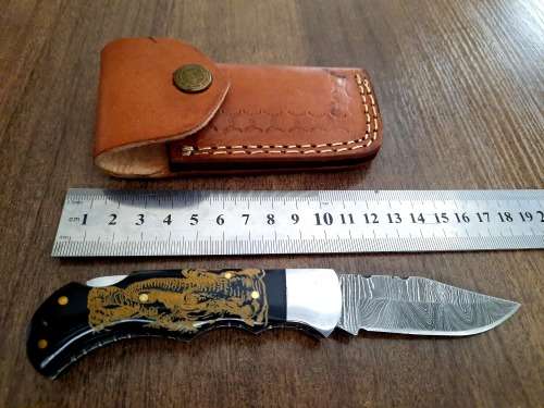 Handmade Damascus steel folding knife with Bull Horn Handle. Art engraved.