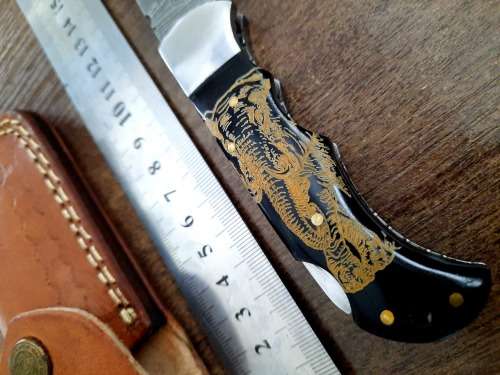 Handmade Damascus steel folding knife with Bull Horn Handle. Art engraved.