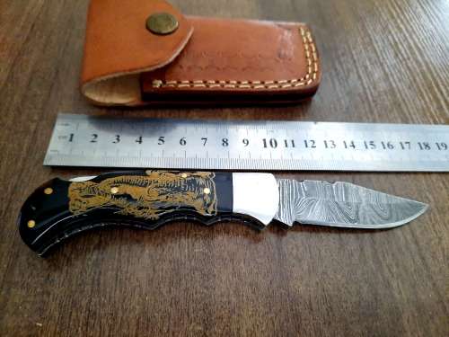 Handmade Damascus steel folding knife with Bull Horn Handle. Art engraved.