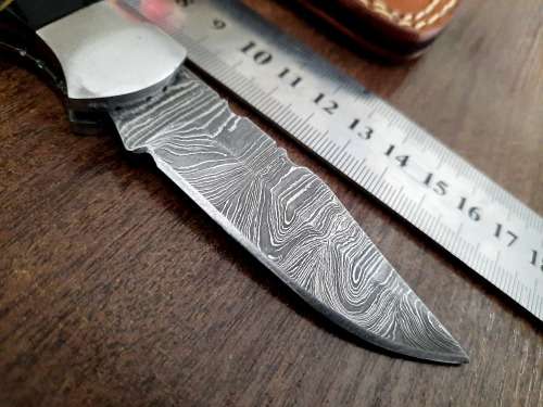 Handmade Damascus steel folding knife with Bull Horn Handle. Art engraved.