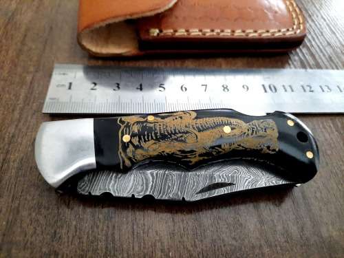 Handmade Damascus steel folding knife with Bull Horn Handle. Art engraved.