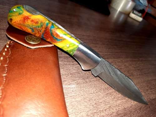 Handmade Damascus steel folding knife with Epoxy Resin handle scales. Leather pouch included.