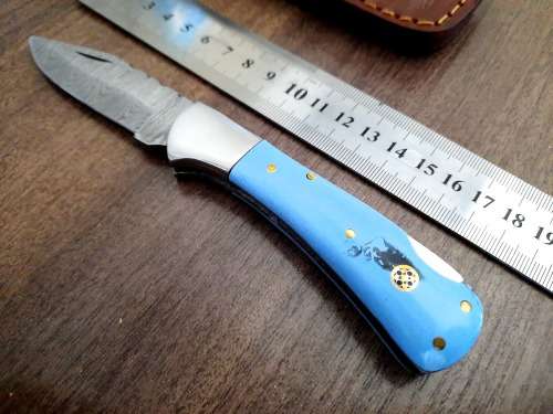 Handmade Damascus steel folding knife with Epoxy Resin handle scales. Leather pouch included.