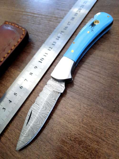 Handmade Damascus steel folding knife with Epoxy Resin handle scales. Leather pouch included.