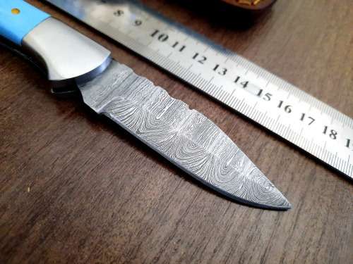 Handmade Damascus steel folding knife with Epoxy Resin handle scales. Leather pouch included.