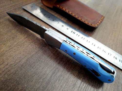 Handmade Damascus steel folding knife with Epoxy Resin handle scales. Leather pouch included.