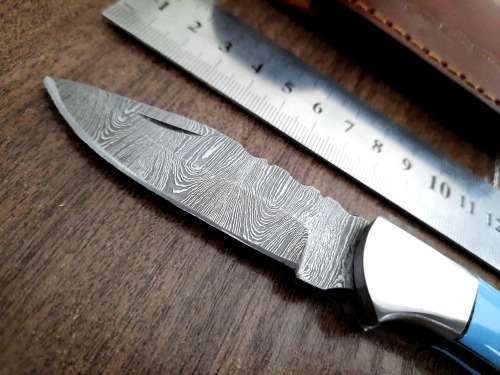 Handmade Damascus steel folding knife with Epoxy Resin handle scales. Leather pouch included.