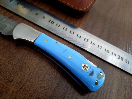 Handmade Damascus steel folding knife with Epoxy Resin handle scales. Leather pouch included.