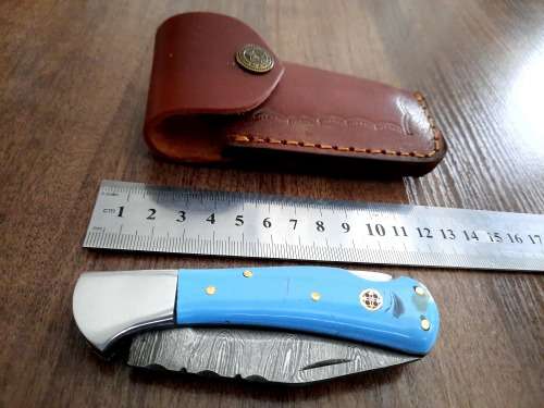 Handmade Damascus steel folding knife with Epoxy Resin handle scales. Leather pouch included.