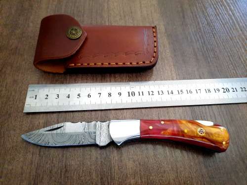 Handmade Damascus steel folding knife with Epoxy Resin handle scales. Leather pouch included.