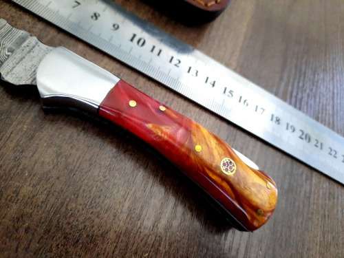 Handmade Damascus steel folding knife with Epoxy Resin handle scales. Leather pouch included.
