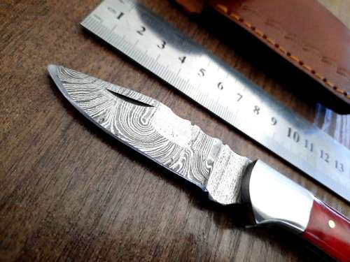 Handmade Damascus steel folding knife with Epoxy Resin handle scales. Leather pouch included.