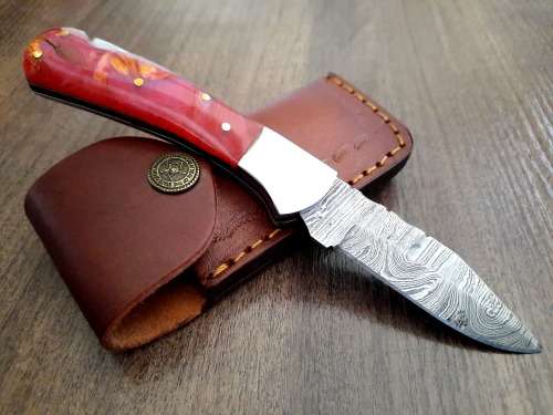 Handmade Damascus steel folding knife with Epoxy Resin handle scales. Leather pouch included.
