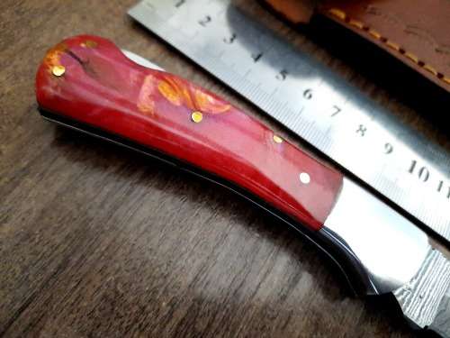 Handmade Damascus steel folding knife with Epoxy Resin handle scales. Leather pouch included.