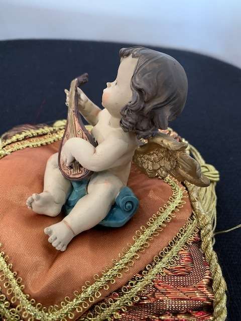 CHERUB PLAYING THE MANDOLIN SITTING ON GOLD BRAIDED CUSHION
