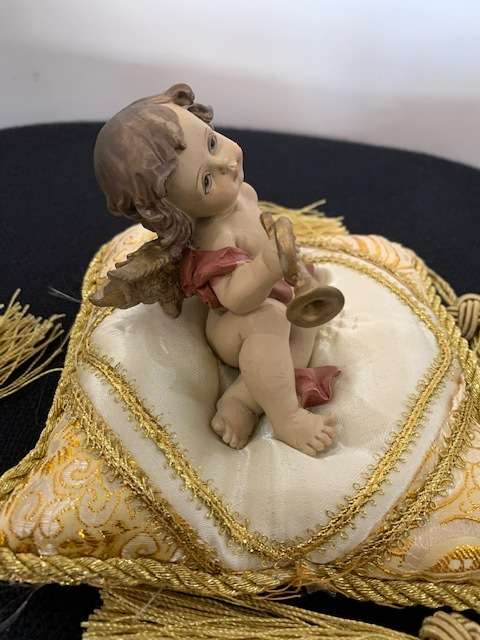 CHERUB HOLDING THE BUGLE SITTING ON GOLD BRAIDED CUSHION
