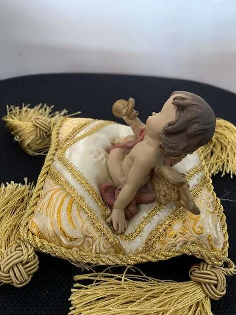 CHERUB HOLDING THE BUGLE SITTING ON GOLD BRAIDED CUSHION