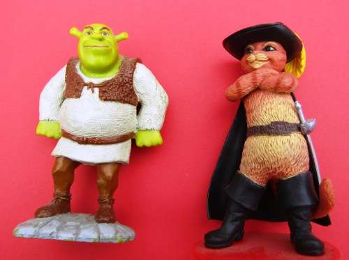 TWO PLASTIC FIGURINES FROM THE VERY POPULAR FILMS "SHREK". SHREK HIMSELF AND PUSS-IN-BOOTS.