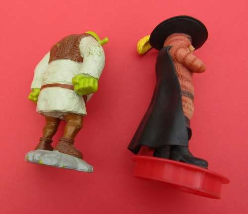 TWO PLASTIC FIGURINES FROM THE VERY POPULAR FILMS "SHREK". SHREK HIMSELF AND PUSS-IN-BOOTS.