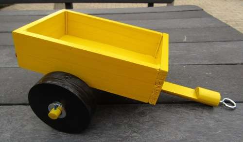 HAND MADE WOODEN TRAILER FOR TRACTOR IN BRIGHT YELLOW. MEDIUM SIZE. VERY STURDY. WOODEN WHEELS.