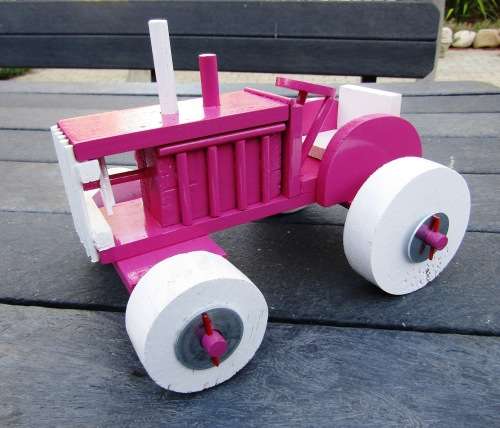 HAND MADE LARGE WOODEN FARM TRACTOR IN HOT PINK. VERY STURDY. NOT A DINKY TOY.