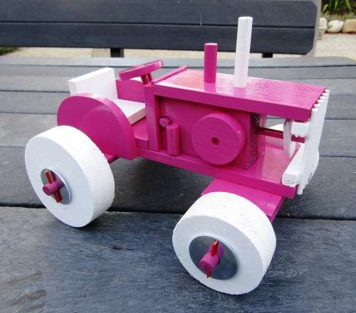 HAND MADE LARGE WOODEN FARM TRACTOR IN HOT PINK. VERY STURDY. NOT A DINKY TOY.