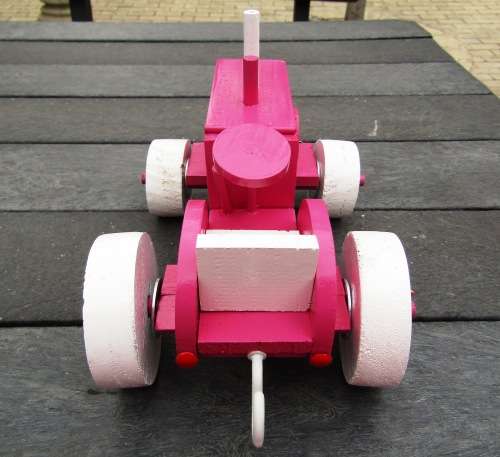 HAND MADE LARGE WOODEN FARM TRACTOR IN HOT PINK. VERY STURDY. NOT A DINKY TOY.