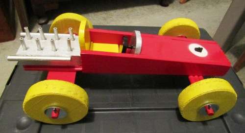 LARGE HAND MADE WOODEN `F1 RACING CAR` IN RED WITH YELLOW WHEELS. TOUGH STRUCTURE. NOT DINKY.