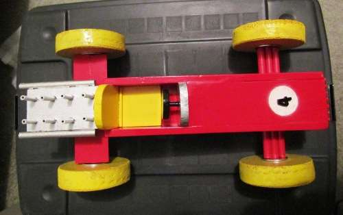 LARGE HAND MADE WOODEN `F1 RACING CAR` IN RED WITH YELLOW WHEELS. TOUGH STRUCTURE. NOT DINKY.