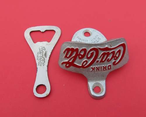 SCARCE `COCA-COLA` METAL BOTTLE OPENERS. ONE VINTAGE AND THE OTHER GENUINE AND UNUSED.