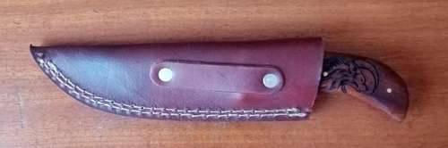 Stunning Damascus steel knife with carved wolf motive handle and leather sheath