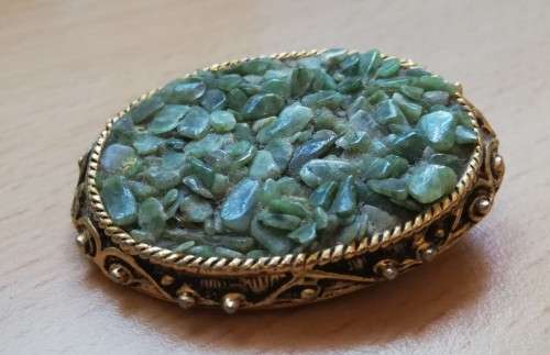 Vintage gold coloured brooch with green semi-precious stones