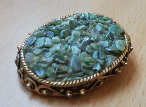 Vintage gold coloured brooch with green semi-precious stones