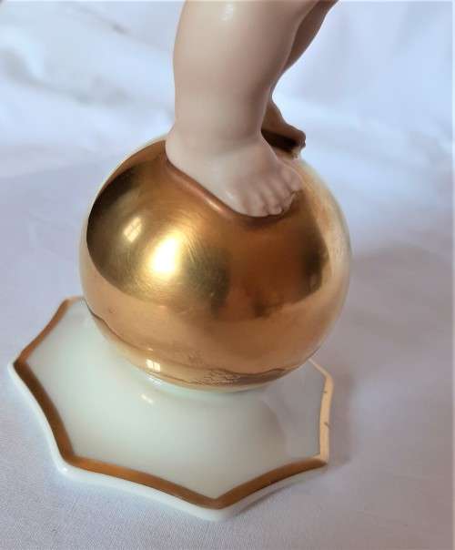 Superb Quality Hutschenreuther Gorgeous fat winged cherub standing on a gold ball, Signed Tutter.