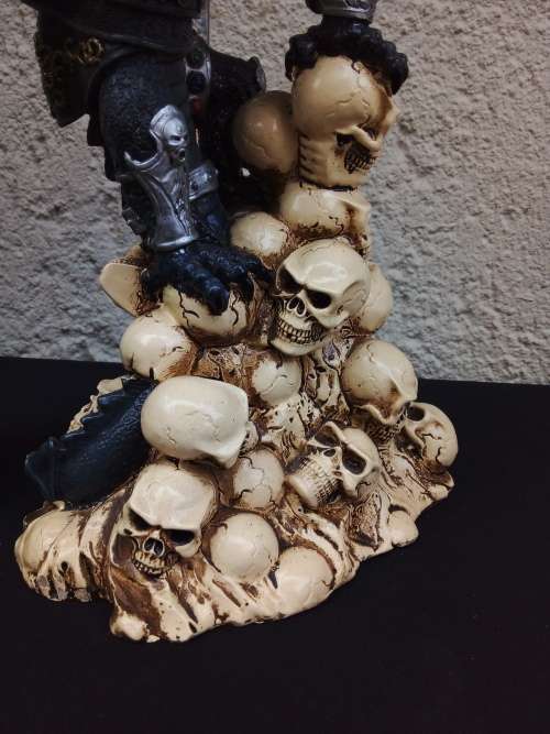 A STUNNING RESIN STATUE OF A DRAGON STANDING ON SKULLS HOLDING A BRASS & STAINLESS SWORD