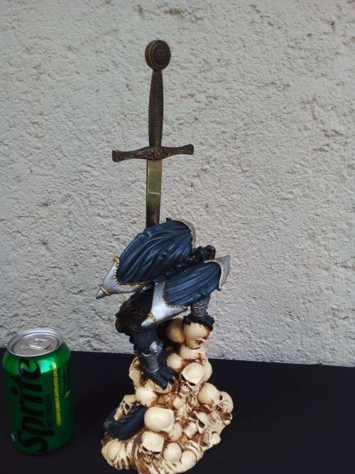 A STUNNING RESIN STATUE OF A DRAGON STANDING ON SKULLS HOLDING A BRASS & STAINLESS SWORD
