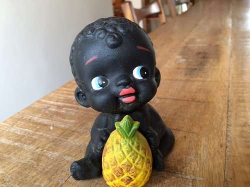 Adorable baby figurine holding a pineapple