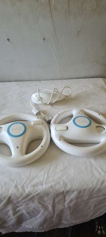 NINTENDO WII CONSOLE INCL.T STEERING AND REMOTES, 2 NUNCHUK ADAPTER, 8 GAME DISCS AND ALL CABLES AS
