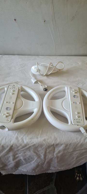 NINTENDO WII CONSOLE INCL.T STEERING AND REMOTES, 2 NUNCHUK ADAPTER, 8 GAME DISCS AND ALL CABLES AS