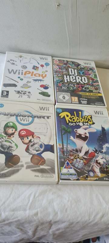 NINTENDO WII CONSOLE INCL.T STEERING AND REMOTES, 2 NUNCHUK ADAPTER, 8 GAME DISCS AND ALL CABLES AS