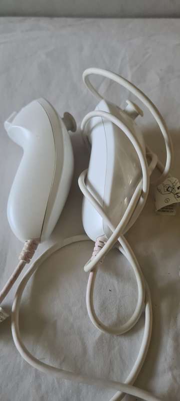 NINTENDO WII CONSOLE INCL.T STEERING AND REMOTES, 2 NUNCHUK ADAPTER, 8 GAME DISCS AND ALL CABLES AS