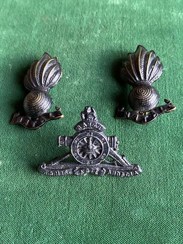 NATAL FIELD ARTILLERY BLACKENED BRONZE CAP BADGE AND COLLAR BADGES(ALSO LATER WORN AS CAP BADGE)APPR