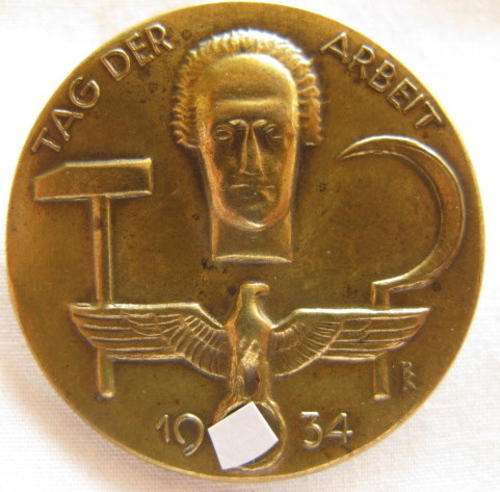 GERMAN 1934 TAG DERARBEIT IN BRASS.  STICK-PIN INTACT.  MAKERS MARKINGS ON BACK.