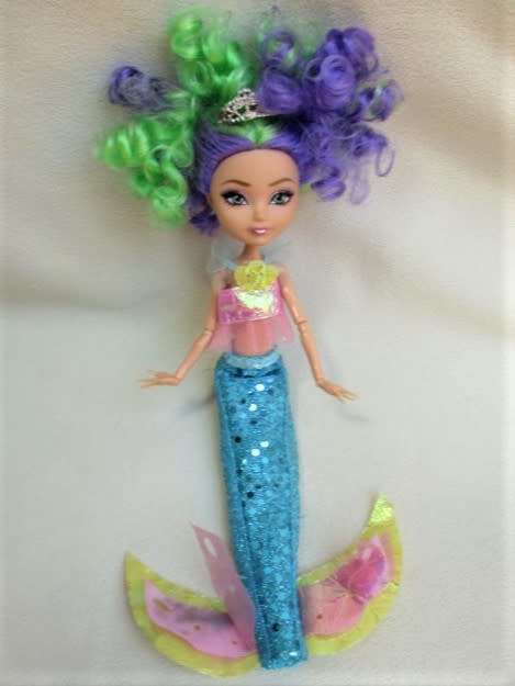 A PRETTY  CURLY HEADED FASHION DOLL IN MERMAID'S COSTUME