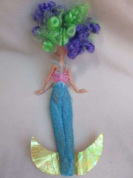 A PRETTY  CURLY HEADED FASHION DOLL IN MERMAID'S COSTUME