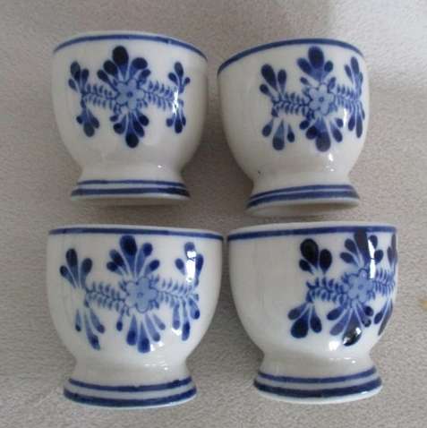 SET OF FOUR VINTAGE HAND PAINTED DELFT EGG CUPS WITH WALL MOUNTED WOODEN STAND