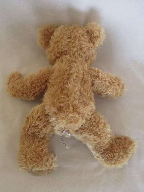 A PRETTY HARRODS BEAR WITH TINSEL IN HIS FUR